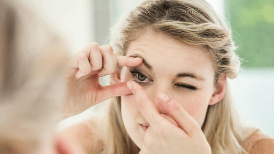 Woman putting contact in her eye