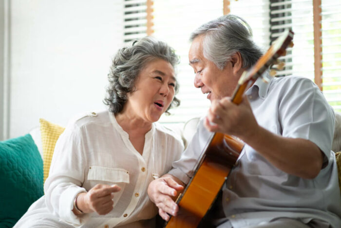 senior couple singing and playing guitar