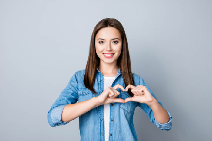 young woman making a heart with her hands