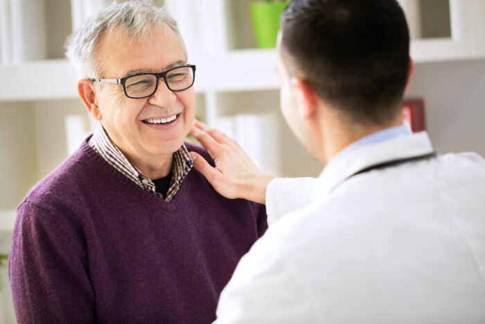 senior man being reassured by doctor